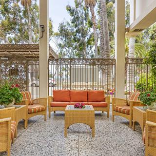 An inviting outdoor seating area with comfortable furniture and lush greenery.