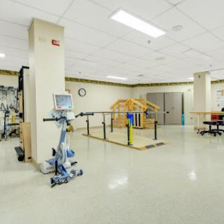 A spacious rehabilitation therapy room equipped with exercise machines and facilities for physical therapy.