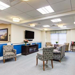 A well-lit living room with patterned chairs, a television, and decorative elements.