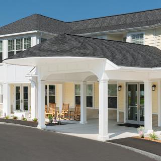 A residential building with a covered entrance and columns.