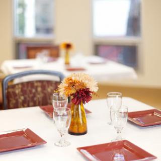 A beautifully arranged dining table with elegant glassware and a centerpiece of fresh flowers.
