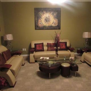A cozy living room featuring beige sofas, a glass coffee table, and elegant decor.