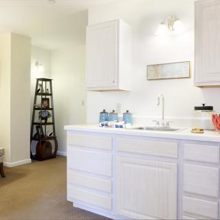 A modern kitchen with white cabinets and minimalist decor.