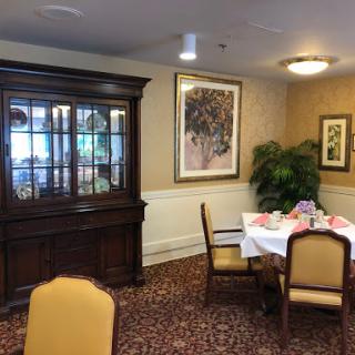 A cozy dining room setup featuring a wooden china cabinet, a dining table with chairs, and decorative artwork.