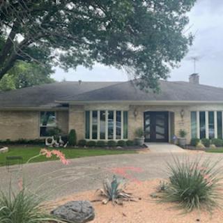 A suburban house with a well-maintained front yard and driveway.