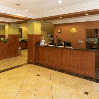 A spacious hotel lobby with a reception desk and warm lighting.