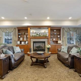 Cozy living room with leather sofas, a central fireplace, and built-in shelves.