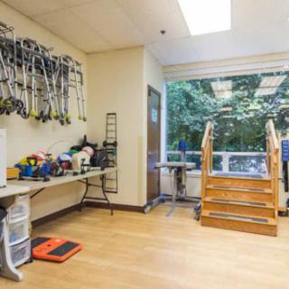 A well-lit therapy room equipped with exercise tools and stairs, designed for rehabilitation activities.