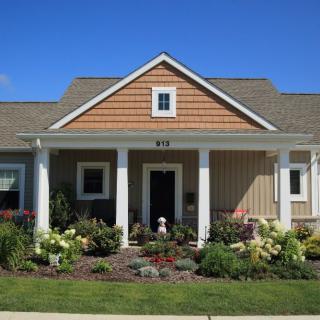 A charming single-story house with a well-maintained garden in the front yard.