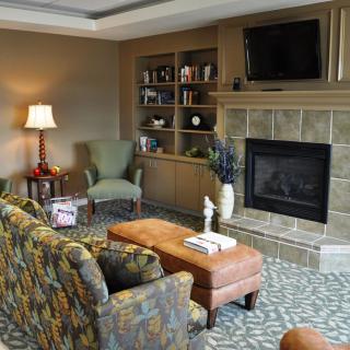 A cozy living room with a fireplace, comfortable seating, and a television.