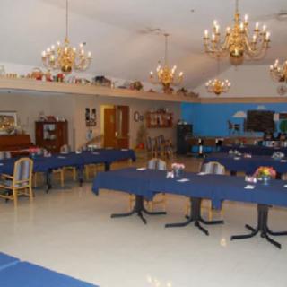 An elegant dining area with chandeliers and neatly arranged tables and chairs.