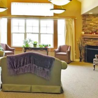 A cozy living room with comfortable seating, a fireplace, and large windows allowing natural light.