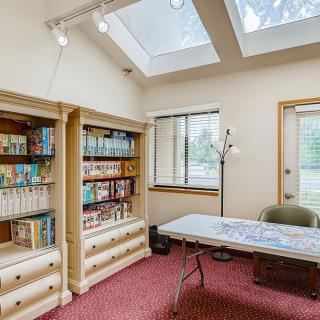 A cozy room with bookshelves, a table, and skylights.