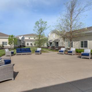 A spacious courtyard with comfortable patio seating and surrounding buildings.