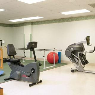A rehabilitation room featuring stationary bikes and exercise equipment.