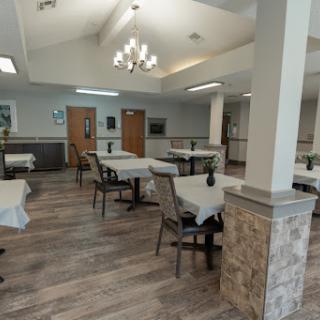 A spacious and modern dining area with elegantly set tables and comfortable seating.