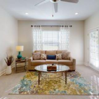 A cozy living room with a sofa, coffee table, and colorful rug.