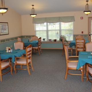 An indoor dining area with tables and chairs arranged neatly under soft lighting.