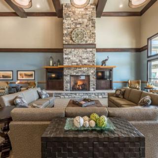 A spacious living room with a stone fireplace and modern decor.