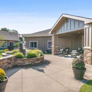 A scenic courtyard with outdoor seating, a fountain, and landscaped plants.