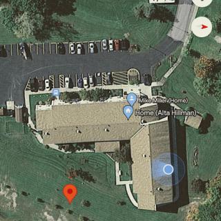 Aerial view of a property showing the layout of buildings and parking area.