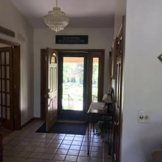 A welcoming entryway featuring a chandelier and natural light streaming through the doors.