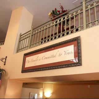 An indoor view featuring a balcony with ornate railings and a framed sign on the wall.