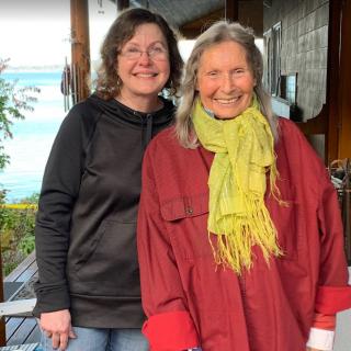 Two women smiling and posing together outdoors.