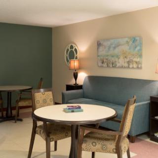 A cozy living area featuring a sofa, round table, and decorative artwork.