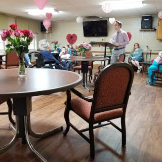 A community gathering decorated with flowers and heart-shaped balloons.