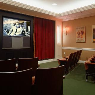 A cozy home theater room with a large screen and comfortable seating.