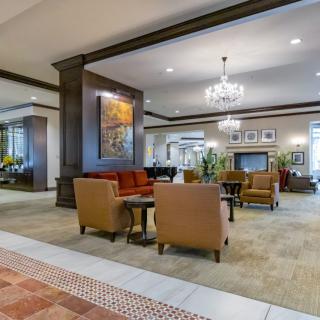 Spacious hotel lobby with elegant seating and a chandelier.