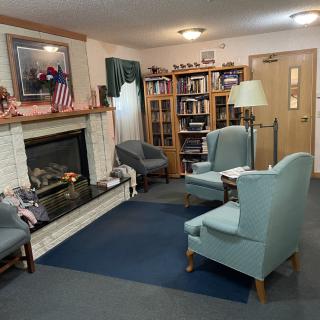 A cozy living room with a fireplace, bookshelves, and comfortable seating.