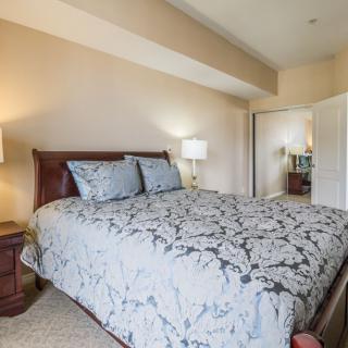 A cozy bedroom with a large bed and bedside lamps.