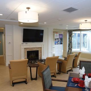 A cozy living room with comfortable seating, a fireplace, and a wall-mounted television.