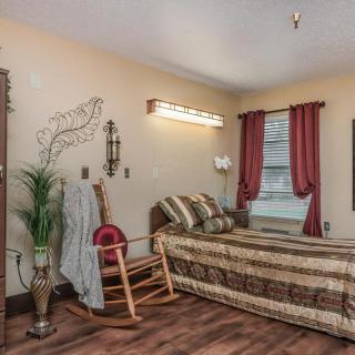 A cozy bedroom with a bed, rocking chair, and decorative elements.