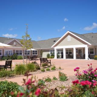 A scenic view of a building's exterior with a landscaped garden and clear blue sky.