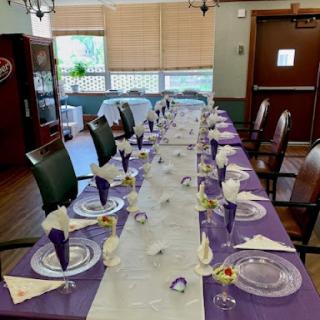 A beautifully arranged dining table with a purple theme, ready for an event.