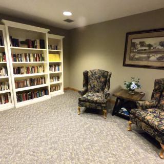 A cozy reading area with bookshelves and armchairs.