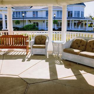 A cozy gazebo with outdoor seating, offering a view of charming houses in the background.