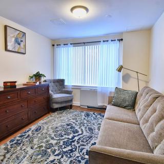 A cozy living room with a couch, armchair, and a decorative rug.