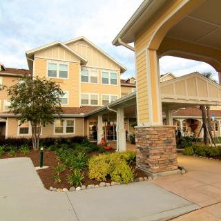A view of a residential building with landscaped surroundings and an inviting entrance.