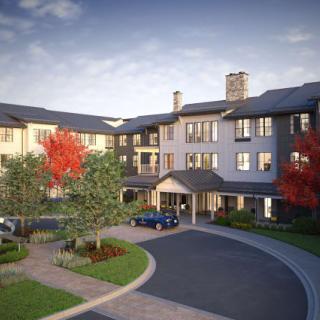 A residential building with a circular driveway and landscaped surroundings.