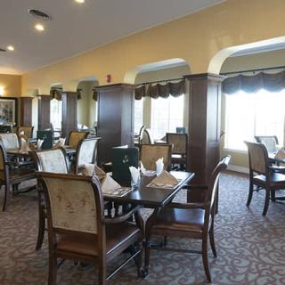 An elegant dining room with neatly arranged tables and chairs, set up for guests.