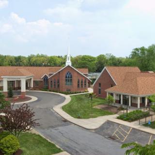 A serene view of a church complex surrounded by lush greenery.