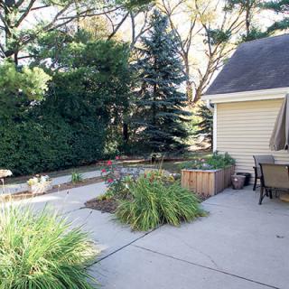 A serene backyard patio with outdoor furniture and lush greenery.