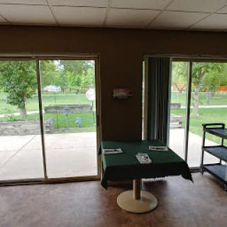 Cozy indoor space with a green tablecloth and a view of the outdoors through sliding doors.