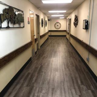 A well-lit hallway featuring decorative wall art and modern flooring.