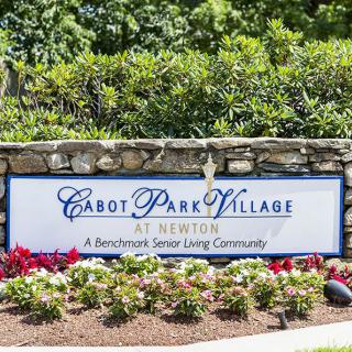 Sign for Cabot Park Village at Newton, surrounded by a landscaped garden.