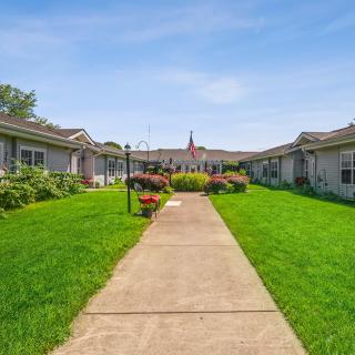 A landscaped garden with a central pathway flanked by residential buildings.